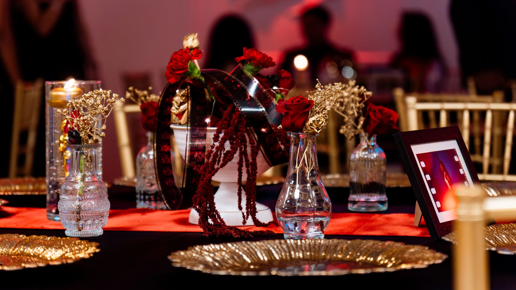 Hollywood gala table setting with film-themed details and feather centerpieces
