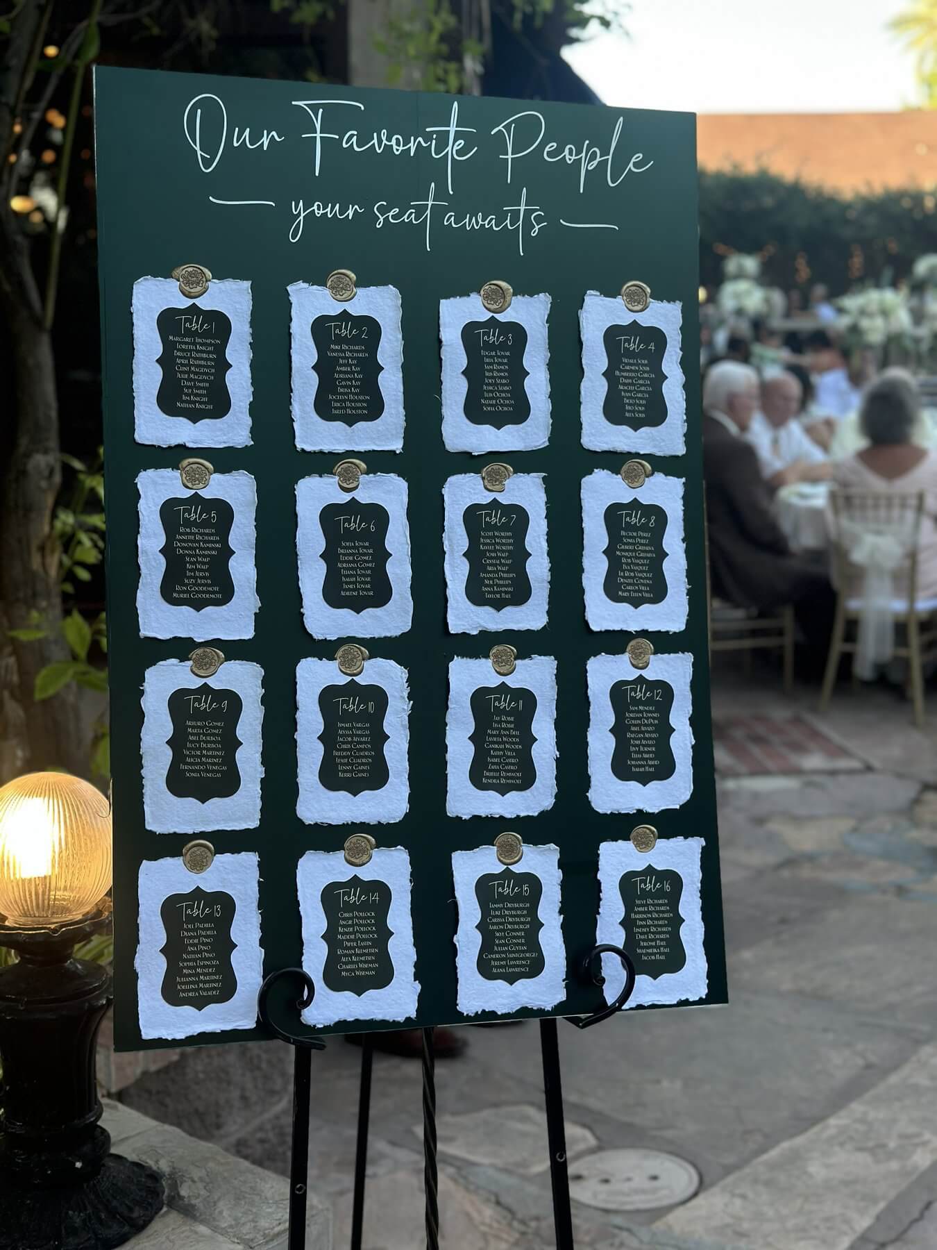 Our Favorite People emerald seating chart with hand-torn paper table cards and gold wax seals